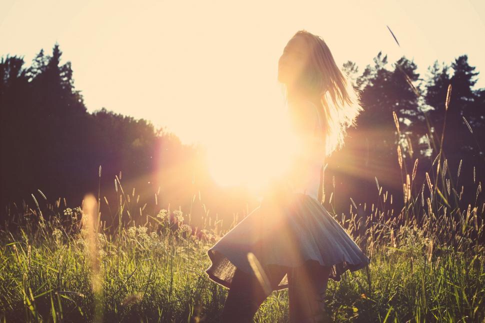 Free Image of Woman Standing in Field at Sunset 