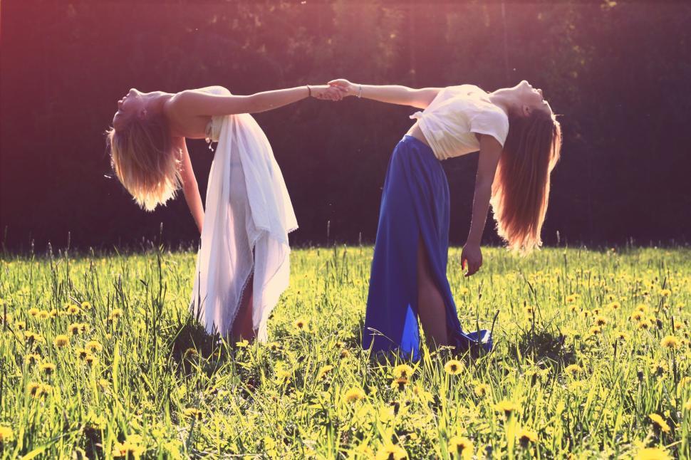 Free Image of Two Women Holding Hands in Field 