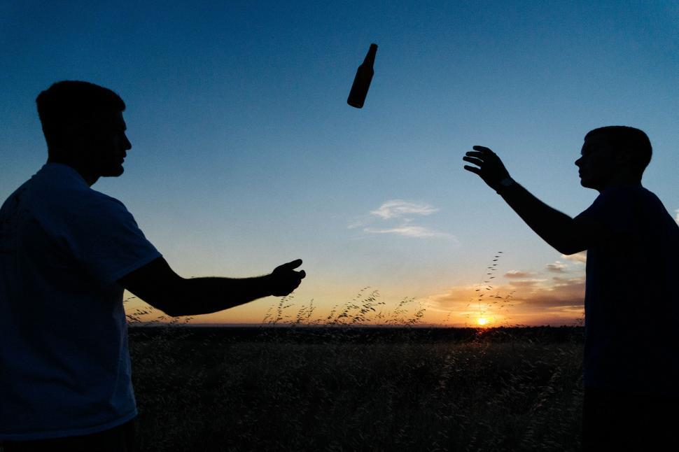 Free Image of Two Men Standing Together in a Field 