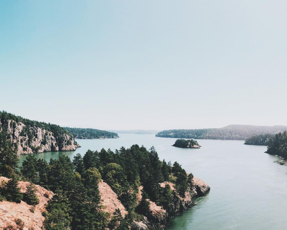 Free Image of Lush Trees Surrounding Vast Water Body 
