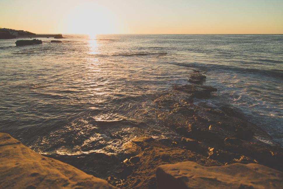 Free Image of Sun Setting Over Ocean With Rocks 