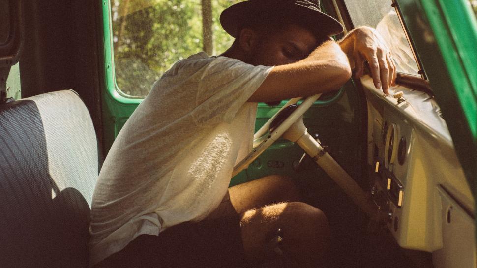 Free Image of Man Sitting in the Back of a Green Truck 