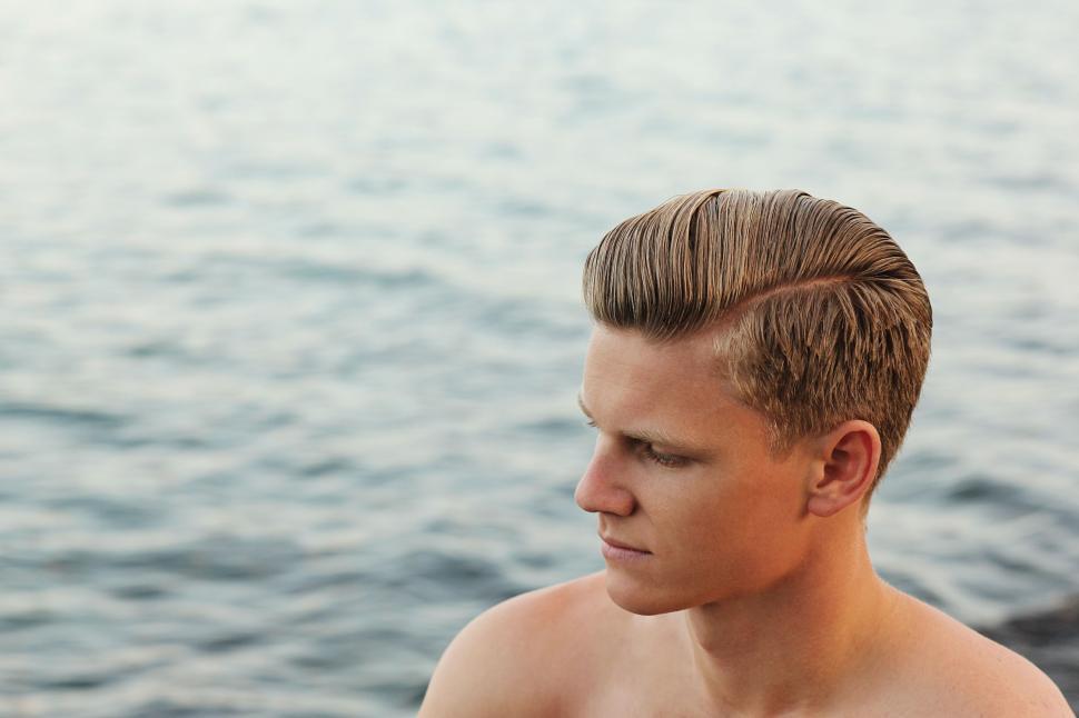 Free Image of Shirtless Man Sitting on Boat in Water 