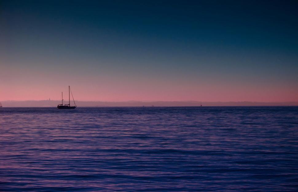 Free Image of Boat Sailing in Ocean at Sunset 
