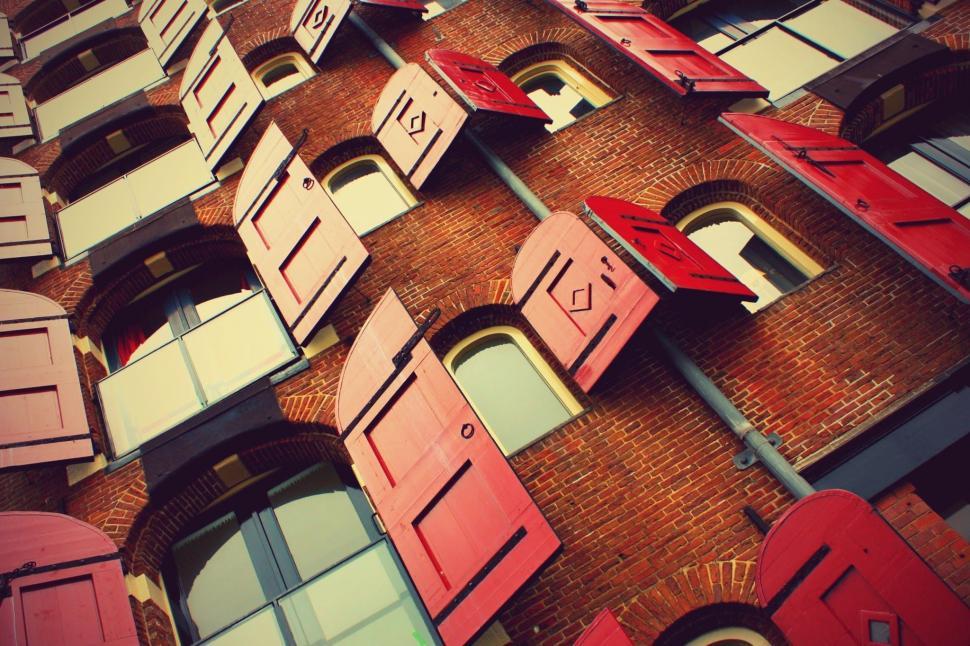 Free Image of Towering Building With Numerous Windows and Shutters 