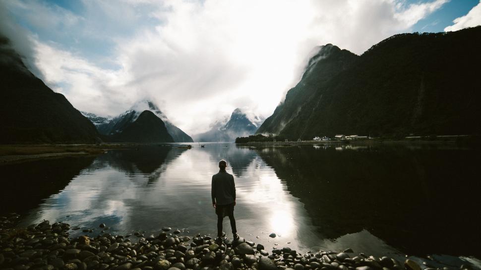 Free Image of Man Standing on Rocky Shore by Body of Water 