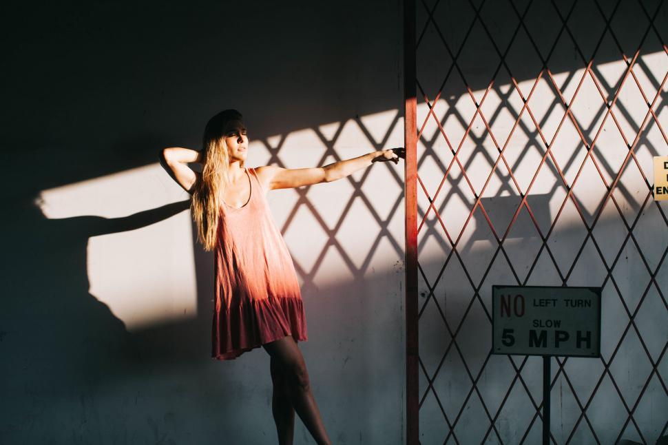 Free Image of Woman Standing Next to Fence With Hands on Hips 
