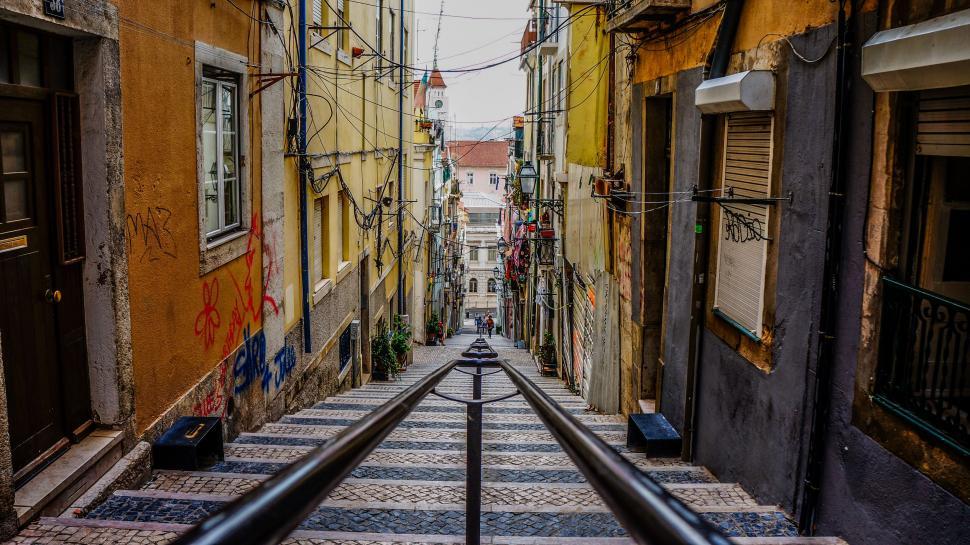 Free Image of Industrial Train Track Cutting Through Narrow Urban Street 