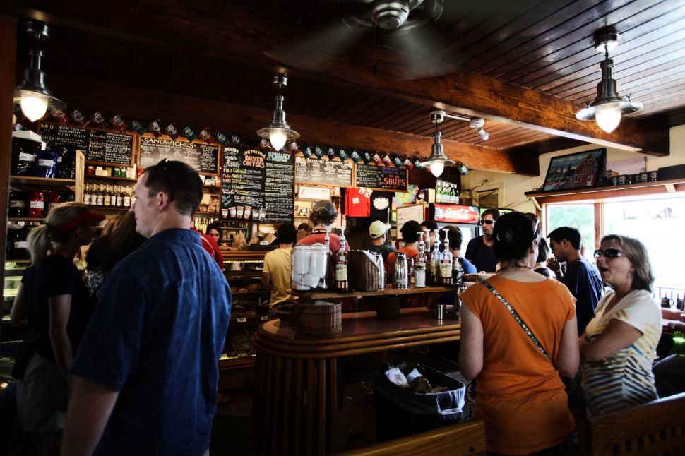 Free Image of Group of People Standing Around a Bar 