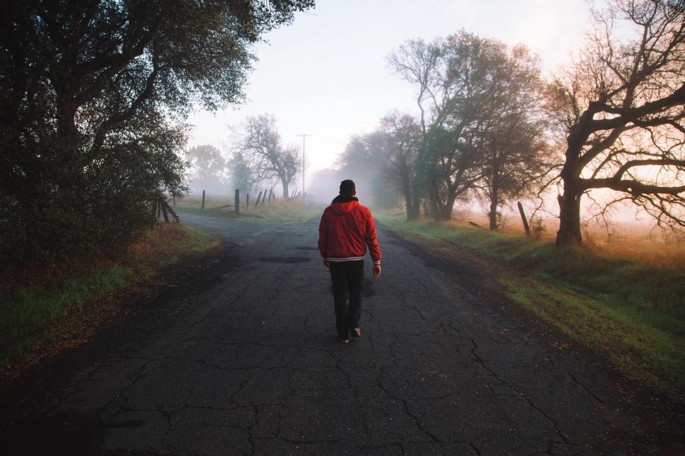 Free Image of Person in Red Jacket Walking Down Road 
