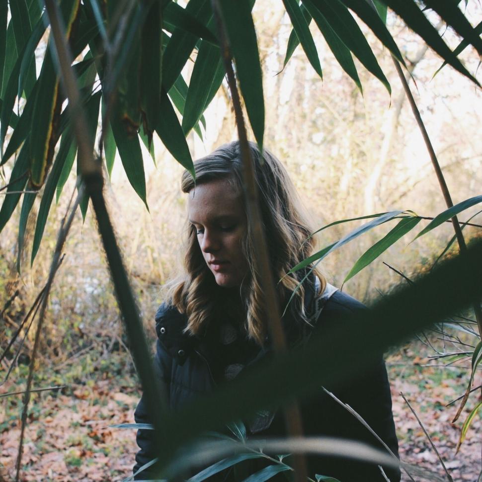 Free Image of Woman Sitting Under Tree in Forest 