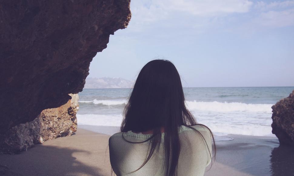 Free Image of Woman Standing on Beach by Ocean 