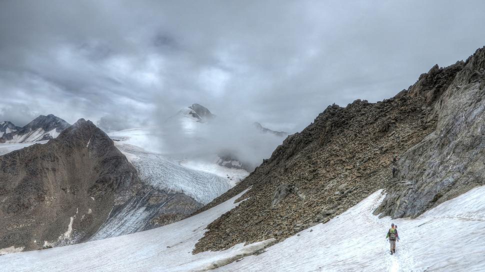 Free Image of Man Hiking Up Snow-Covered Mountain 