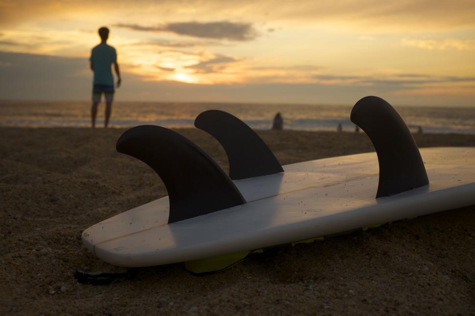 Free Image of Man Standing Near Surfboard on Beach 