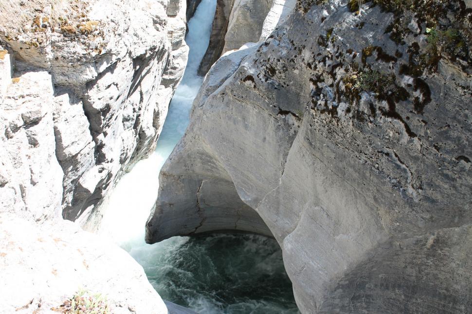 Free Image of Man Standing on Rock by River 