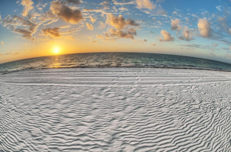 Free Image of Sun Setting Over Ocean on Beach 