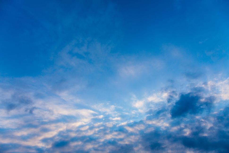 Free Image of Plane Flying Through Cloudy Blue Sky 