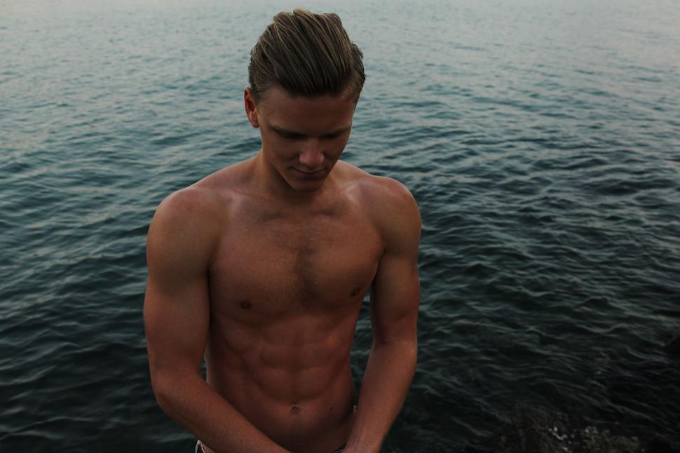 Free Image of Shirtless Man Standing on Boat in Water 