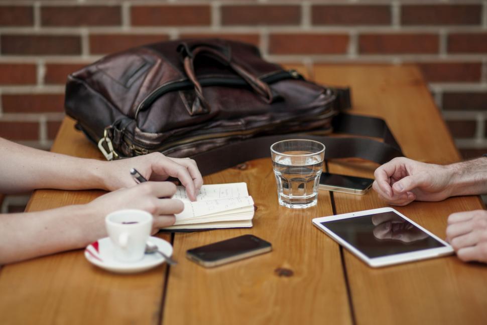 Free Image of Couple Sitting at Wooden Table 
