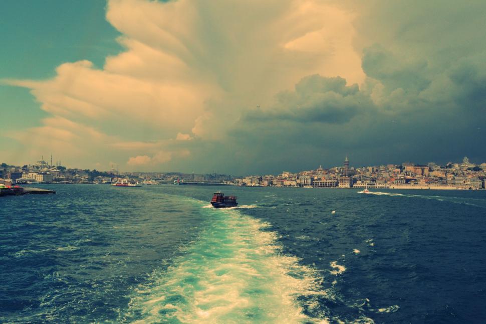 Free Image of Boat Travelling Down a Water Body Under a Cloudy Sky 