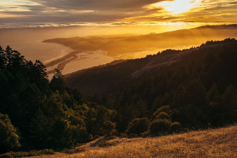 Free Image of Sun Setting Over Mountains and Water 