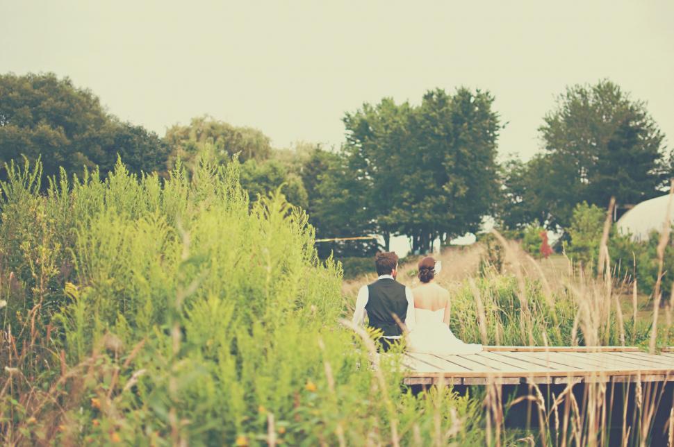 Free Image of Bride and Groom Walking Across a Bridge 