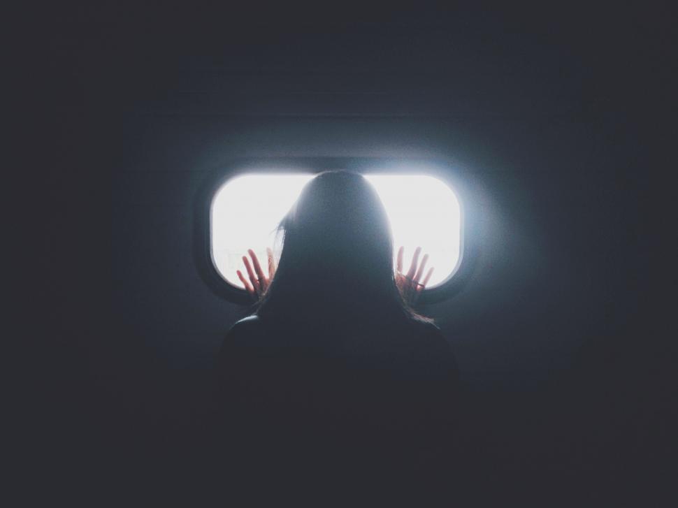 Free Image of Person Standing in Front of Window in Dark 