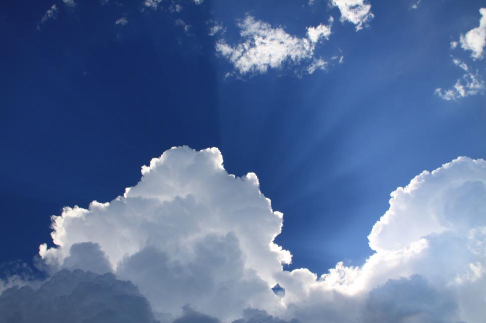 Free Image of Plane Flying Through Blue Cloudy Sky 