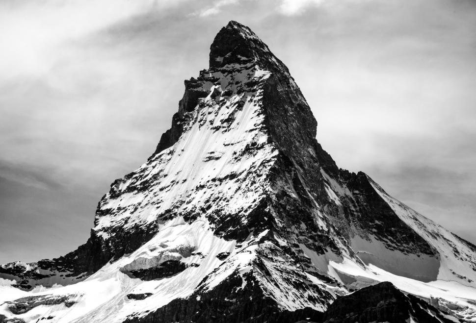 Free Image of Majestic Snow-Covered Mountain Under Cloudy Sky 