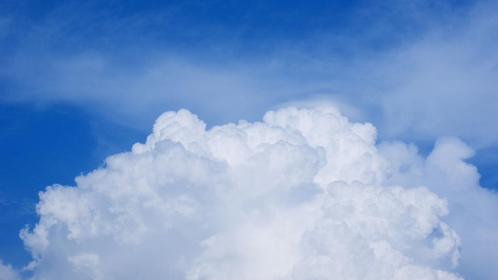 Free Image of Plane Flying Through Blue Cloudy Sky 