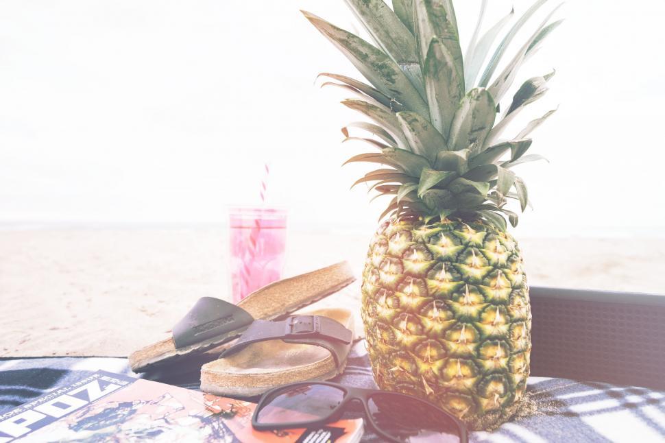 Free Image of Pineapple Resting on Towel Beside Flip Flop 