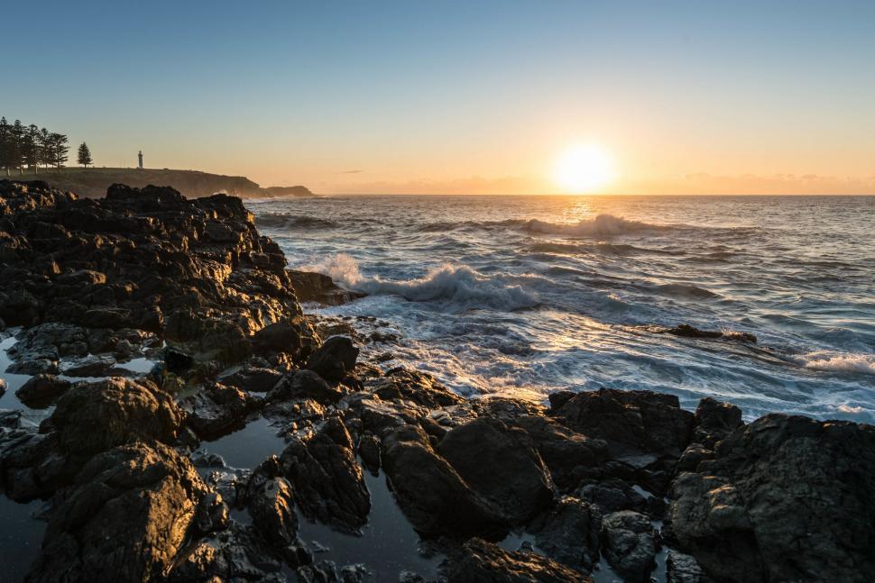 Free Image of Sun Setting Over Ocean and Rocks 