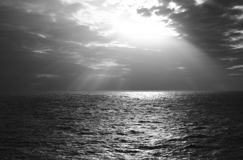 Free Image of Sun Shining Through Clouds Over Ocean 