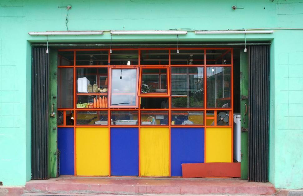 Free Image of Blue and Yellow Building With a Bench 