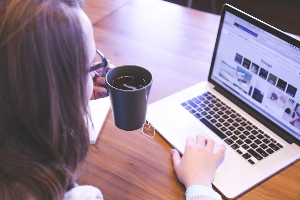 Free Image of Woman Sitting at Table Using Laptop Computer 