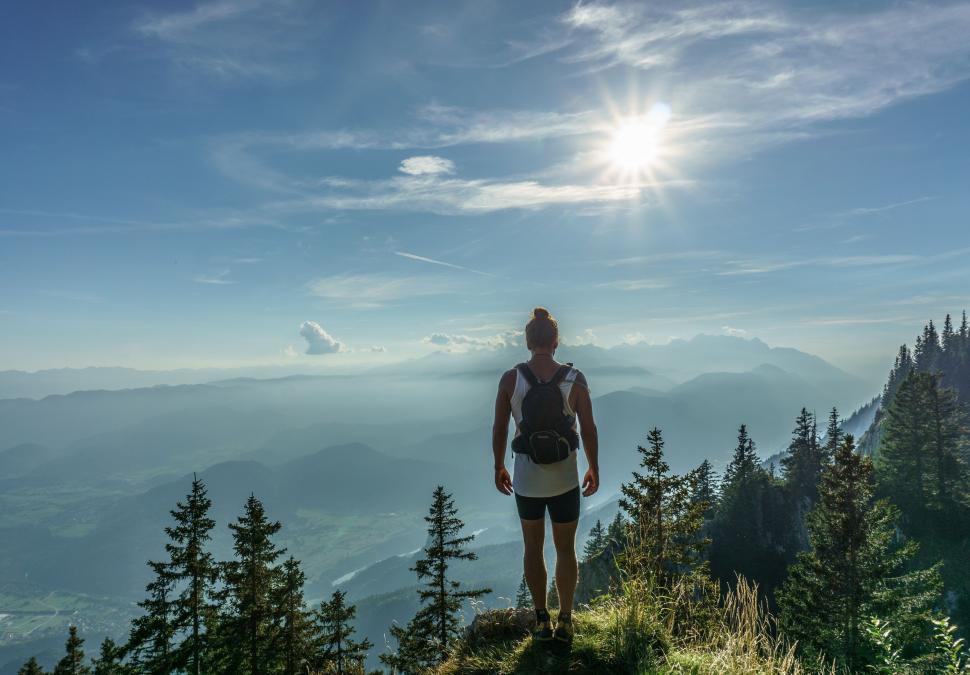 Free Image of Man Standing on Top of Lush Green Hillside 