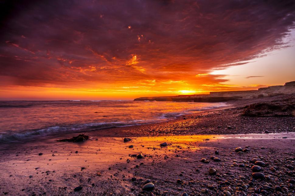 Free Image of Sun Setting Over Ocean on Beach 