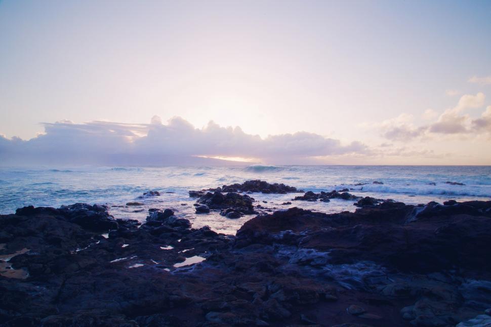 Free Image of Sun Setting Over Ocean and Rocks 