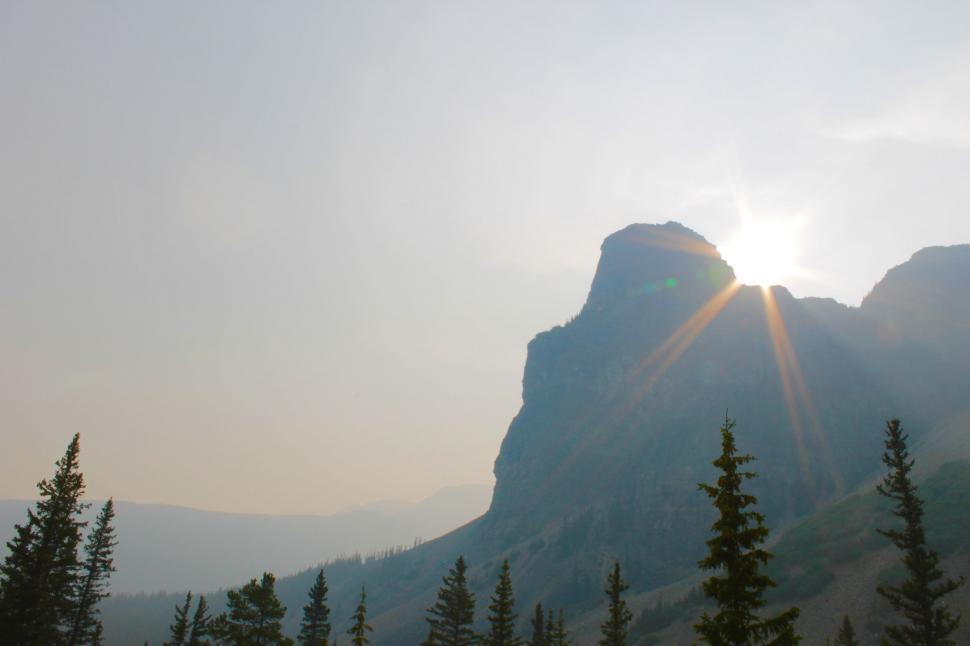Free Image of Sun Shines Through Clouds Over Mountains 