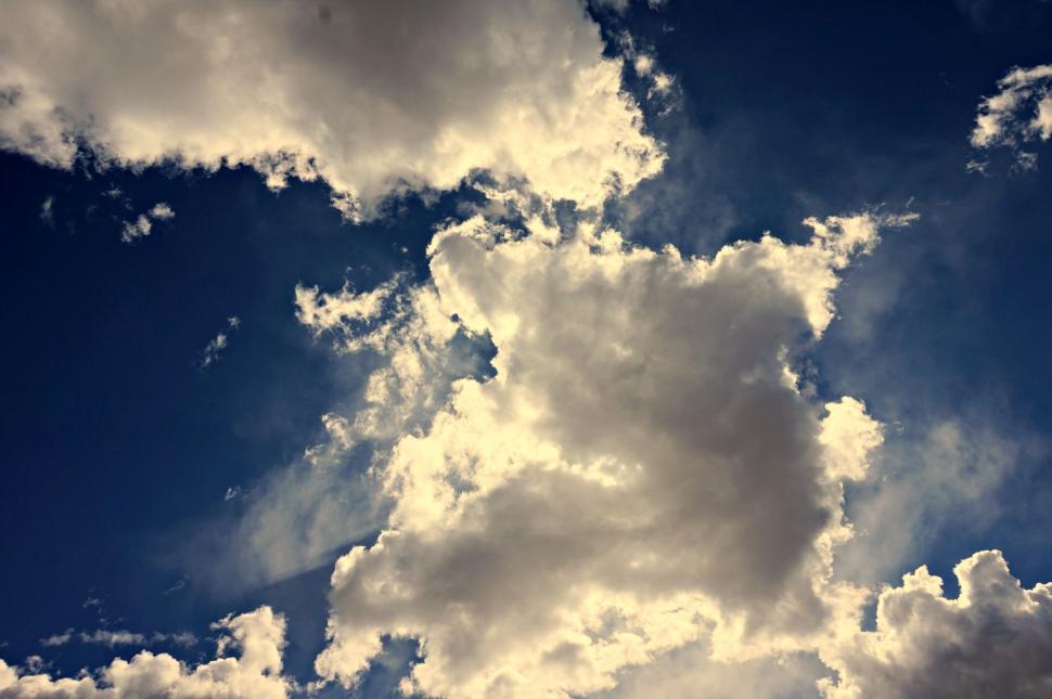 Free Image of Jet Flying Through Cloudy Blue Sky 