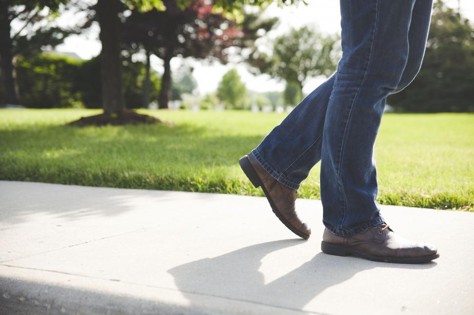 Free Image of Person Walking on Sidewalk in Park 