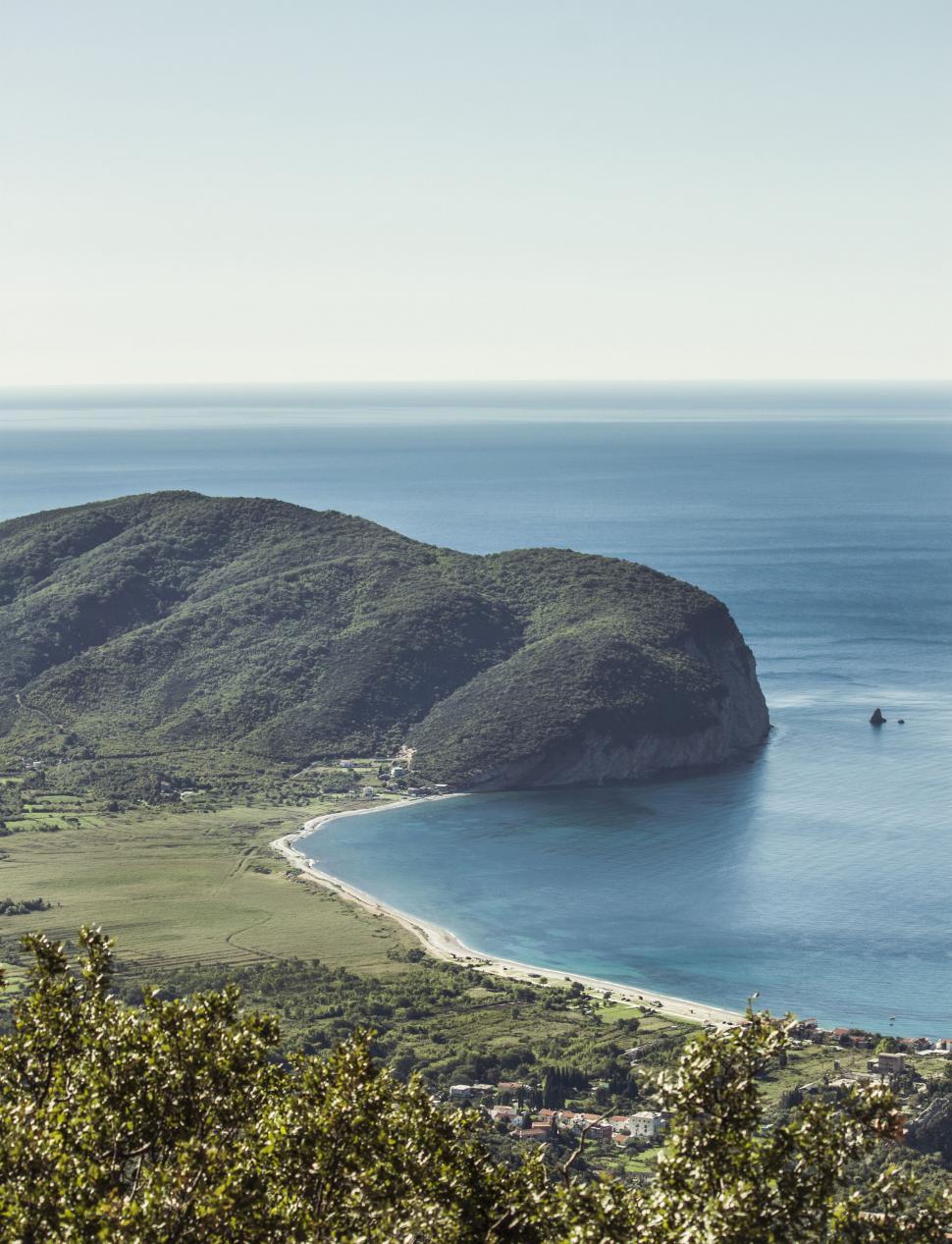 Free Image of Expansive Water Body Next to Lush Green Hillside 
