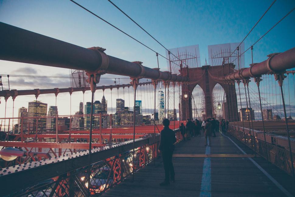 Free Image of Person Standing on Bridge With City Background 