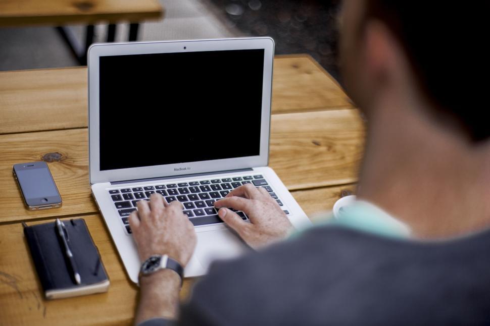 Free Image of Man Sitting at Table Using Laptop Computer 