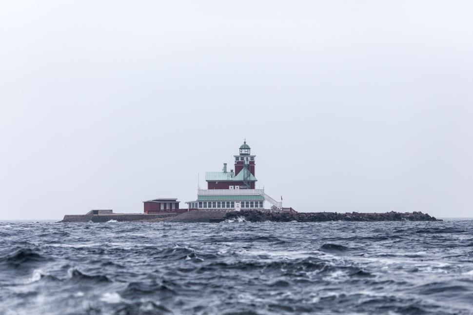 Free Image of Lighthouse Standing in the Middle of a Body of Water 