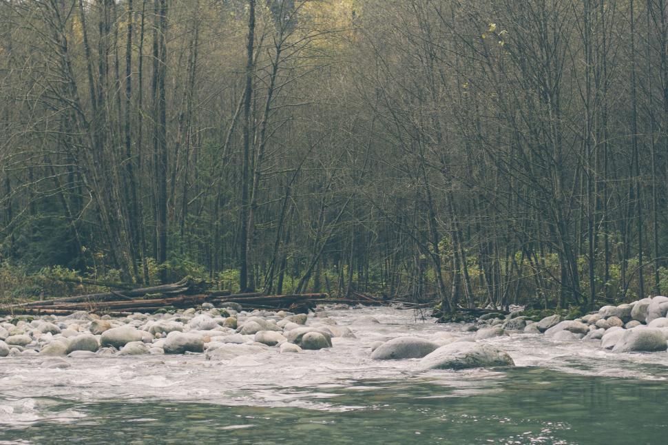 Free Image of Man Standing on Rock in Middle of River 