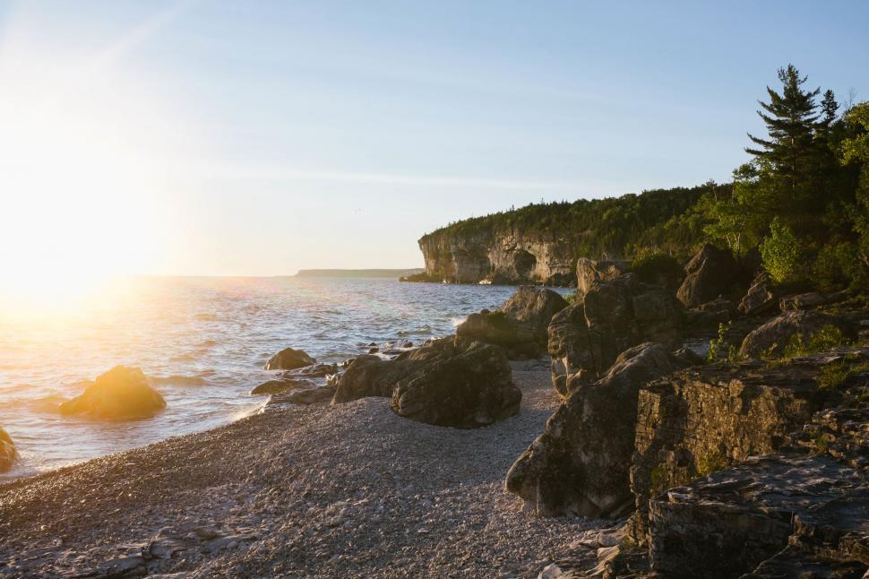 Free Image of The Sun Sets on a Rocky Beach 