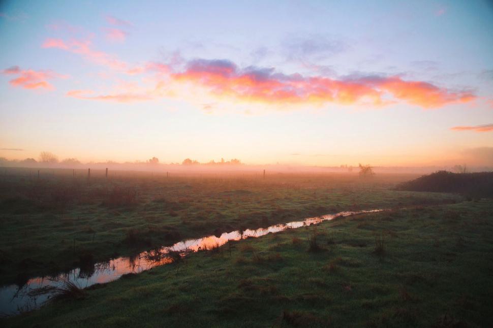 Free Image of Sun Setting Over Grassy Field 