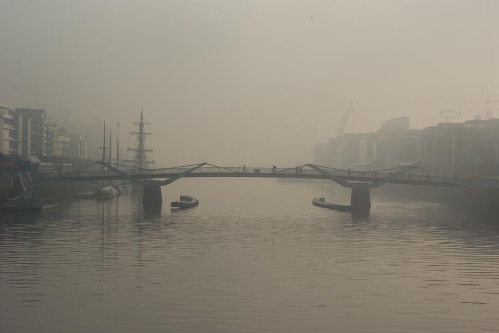 Free Image of Boat Traveling Down River Next to Bridge 