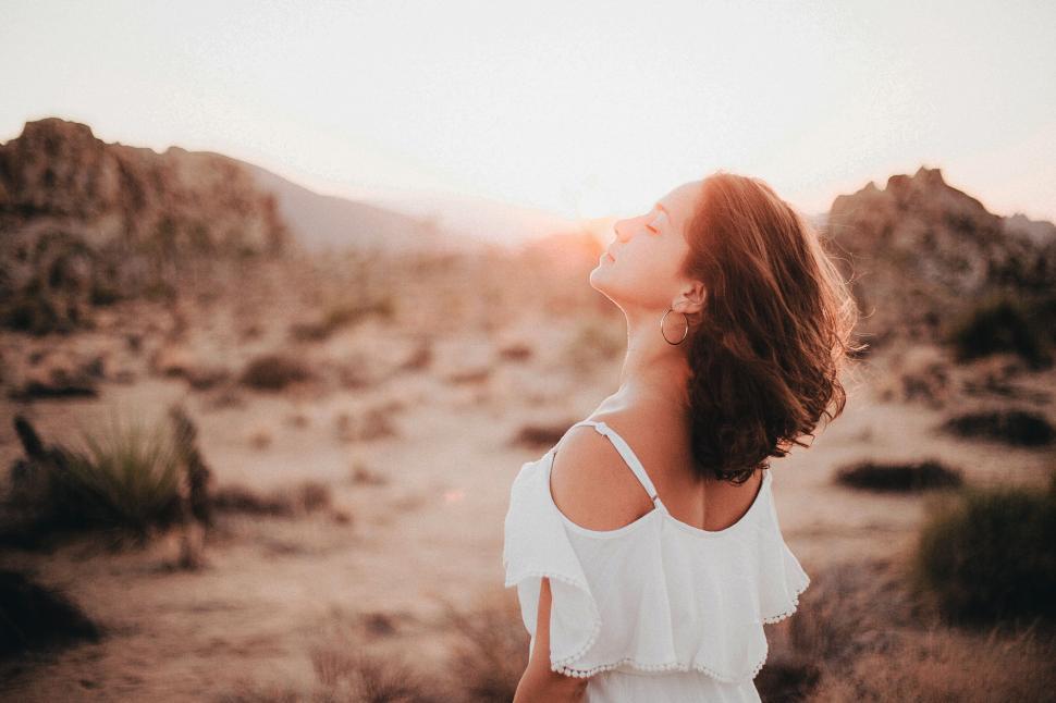 Free Image of Woman in White Dress Standing in Desert 